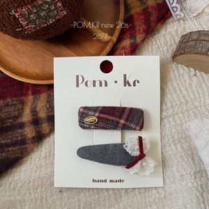 Detailed view of red plaid hair clips with lace bows and LOVE metal charms on a card