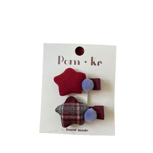 Handmade plaid and solid red star hair clips with soft pompom detail for girls