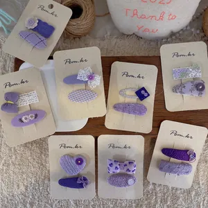 Handmade purple fabric hair clips for girls with lace embroidery and bow details
