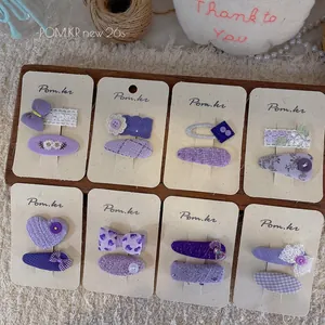 Set of 8 pairs purple Korean style fabric bow and daisy hair clips on display