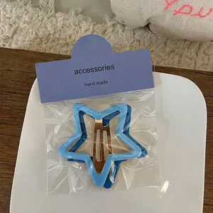 Détail de barrettes à cheveux en forme d'étoile bleue avec clips dorés et emballage