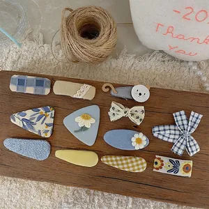 Handmade blue fabric hair clips set for girls featuring floral and cat patterns