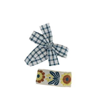 Blue fabric hair clip set with gingham bow and floral embroidery on white background