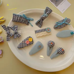 Détails de 9 pinces à cheveux à carreaux bleus et perles sur une assiette en céramique blanche
