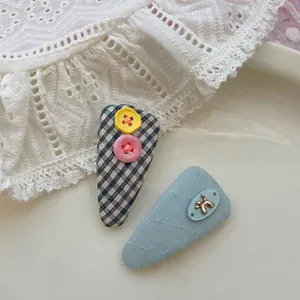 Détails des barrettes à carreaux avec boutons colorés et petit chien doré en métal