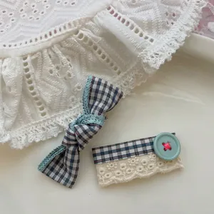 Détail de barrettes à carreaux avec dentelle et clip bouton sur une assiette blanche