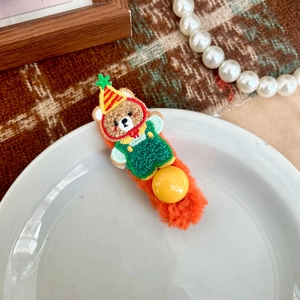 Dettaglio molletta per capelli in peluche con orsetto ricamato e velluto arancione