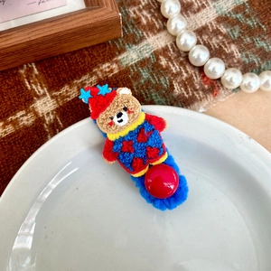 Dettaglio del fermaglio per capelli con orsetto ricamato e base in peluche blu