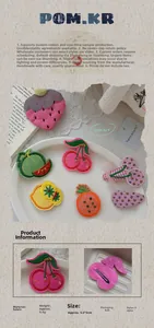 Détail des barrettes à cheveux brodées aux motifs de fruits comme cerise et ananas