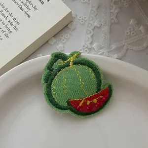 Détail d'une barrette à broderie pastèque faite main avec perles rouges et finitions soignées