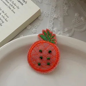 Détail de la barrette ananas brodée avec perles 3D sur un plateau en céramique