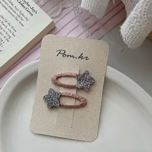 Close-up of pink woven star hair clips for girls on a decorative white plate
