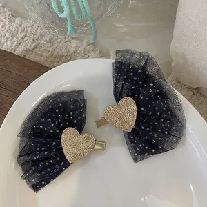 Detail of glitter heart hair clips with navy gold-dot mesh on a white ceramic plate