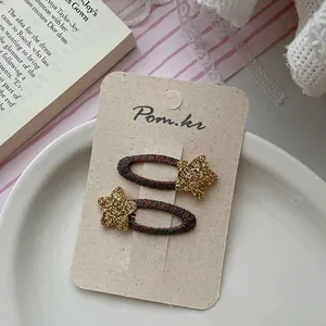 Detail of star-shaped glitter hair clips with woven texture on beige card for girls