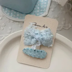 Détail de la pince à cheveux nœud bleu et épingle en tweed sur carte de support