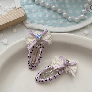 Dettaglio di fermagli per capelli a pois fatti a mano con pizzo e piccoli cristalli