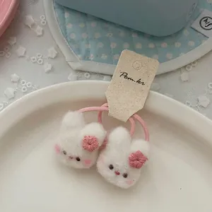 Detalle de coleteros de conejo de peluche blanco con bordado floral rosa y elásticos
