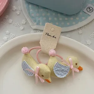 Detalle de gomas para el pelo de pato amarillo con encaje y lazos en un plato