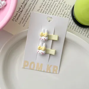 Detailopname van schattige 3D-konijnenhaarspelden met roze wangen en gele strikjes