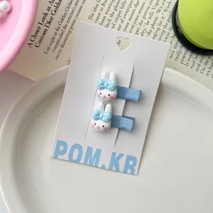 Detailweergave van twee schattige konijn-haarspeldjes met blauwe strikjes op kaart