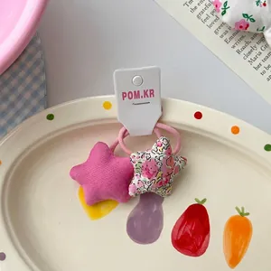 Détail de deux pinces à cheveux en tissu en forme d'étoile sur carte décorative
