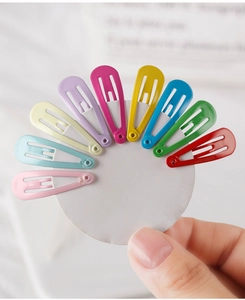Détail de neuf barrettes colorées en métal en forme de goutte sur carte