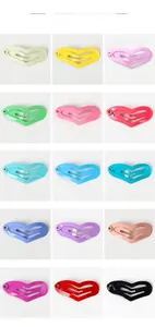 Macro shot of 15 colorful heart-shaped mini metal hair clips on white background
