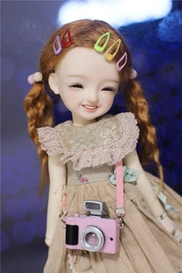 Colorful 2cm mini snap hair clips shown on a doll to demonstrate petite size and fit