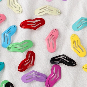 Mini heart-shaped colorful metal snap hair clips for pets and children on white fabric