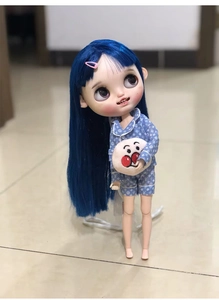 Macro shot of custom doll in blue LV pattern pajamas holding an Anpanman pillow