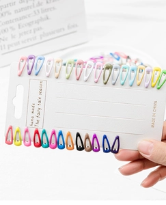 Close-up of 28 mini colorful water drop pet hair clips displayed on a white card