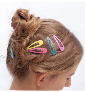 Detailed view of matte candy-colored teardrop snap hair clips worn in a braided hairstyle
