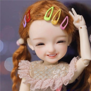 Detailed view of colorful 2cm mini metal hair clips worn on a doll's brown curly hair