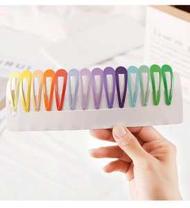 Close-up of fourteen colorful candy-colored metal teardrop hair clips on white card