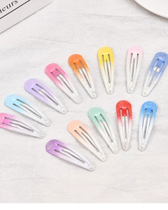 Detailed view of 12-piece colorful gradient glitter BB hair clips on white fabric