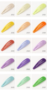 Macro display of 15 colorful candy-colored metal snap hair clips in a grid layout