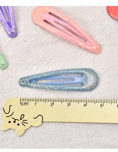 Nahaufnahme von 5cm bunten Glitzer-BB-Haarspangen auf weißem Strickhintergrund