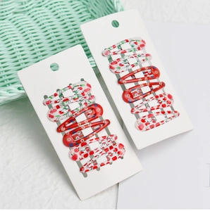 Close-up of 12-piece drip oil fruit pattern snap hair clips on white card displays