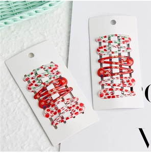 Detail shot of printed BB hair clips with cherry and floral patterns on card