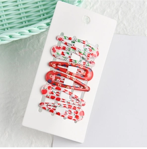 Close-up of 6-piece children's BB clips with cherry and floral prints on a card