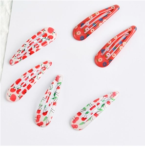 Flat lay of 6 fruit and floral printed drop glue BB hair clips for girls on white background
