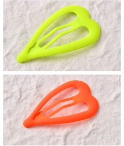 Close-up of matte neon heart hair clips in vibrant yellow-green and orange colors
