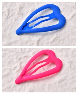 Detail of matte heart-shaped BB clips in neon pink and blue with smooth frosted finish