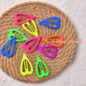 Barrettes BB en forme de cœur mat aux six couleurs néon vives sur un tapis de paille