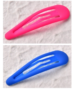 Detailed view of matte pink and blue snap hair clips with smooth rubber coating finish