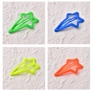 Detailed view of matte star hair clips in neon green, bright blue, yellow and orange colors