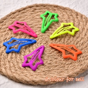 Set of 6 colorful matte hollow star-shaped hair clips on a natural woven mat background