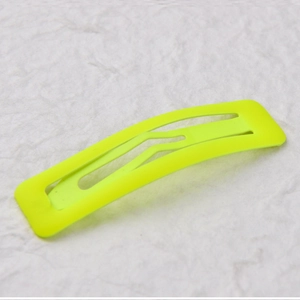 Detailed close-up of a fluorescent yellow 7cm matte paint BB hair clip on textured paper