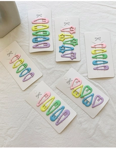 Vue macro de barrettes à cheveux en émail macaron coloré en forme de cœur et d'étoile