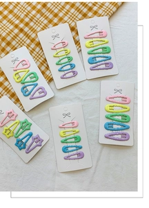 Vue détaillée de barrettes à cheveux en métal macaron en forme de cœur et d'étoile sur cartes